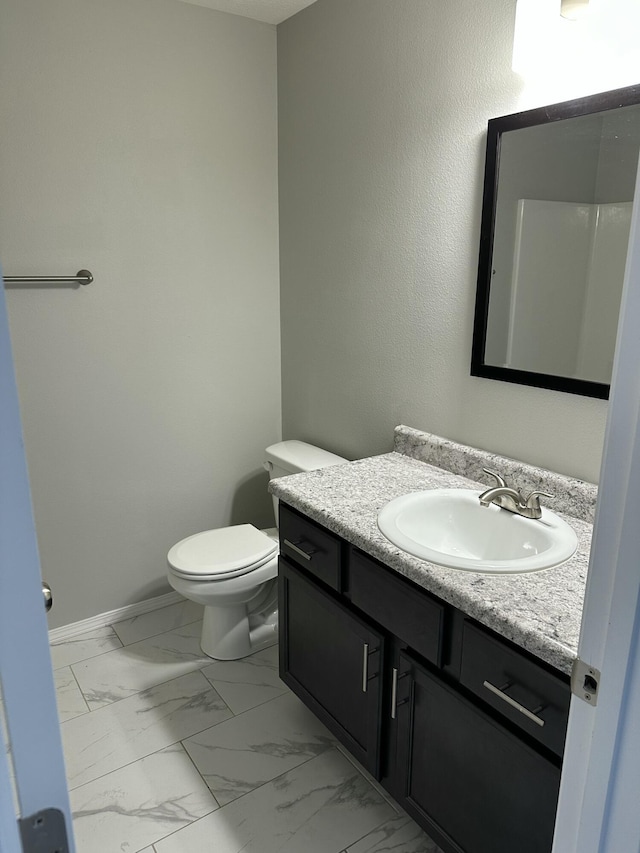 bathroom with marble finish floor, baseboards, vanity, and toilet