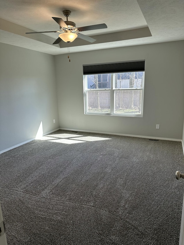 unfurnished room with a textured ceiling, carpet flooring, a ceiling fan, and baseboards