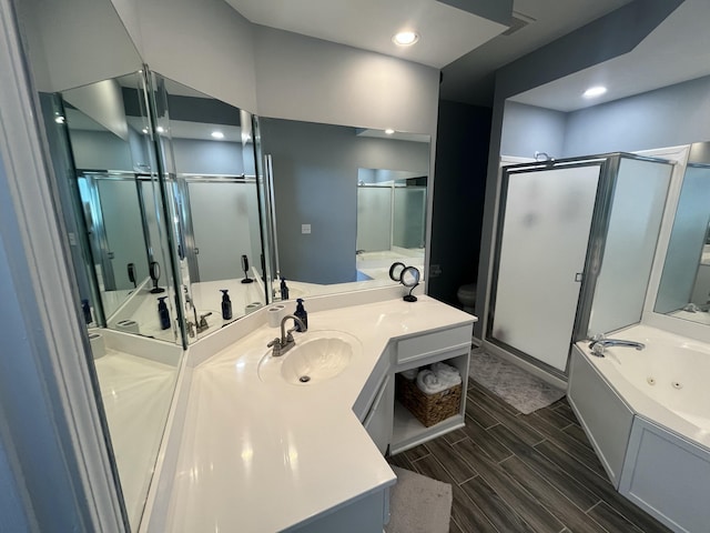 bathroom featuring vanity, visible vents, wood tiled floor, a whirlpool tub, and a shower stall