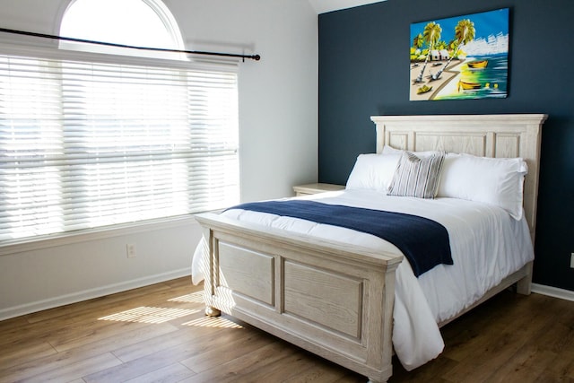 bedroom with baseboards and wood finished floors