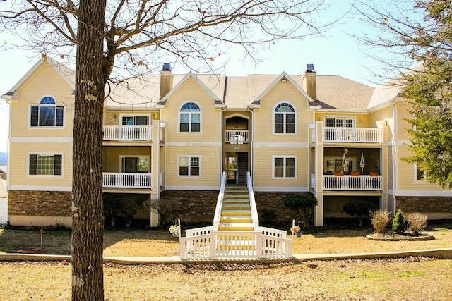 view of front facade with stairs and a chimney