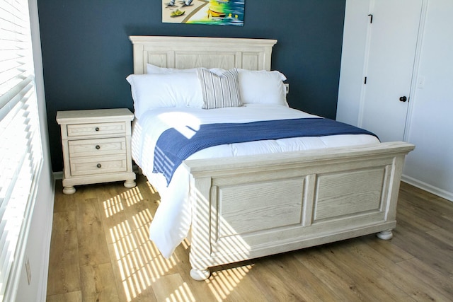 bedroom with wood finished floors and baseboards