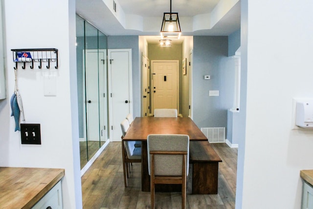 dining space featuring visible vents, baseboards, and wood finished floors