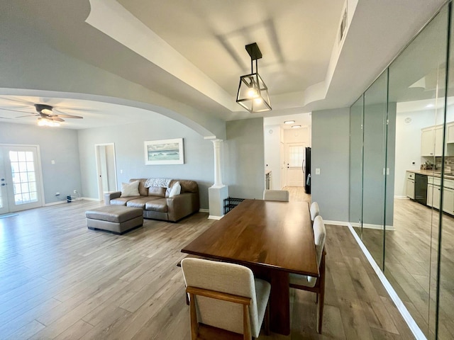 280 Woodland Dr Unit 2D, Branson, MO 65616 - dining space with arched walkways, ornate columns, a raised ceiling, and light wood finished floors