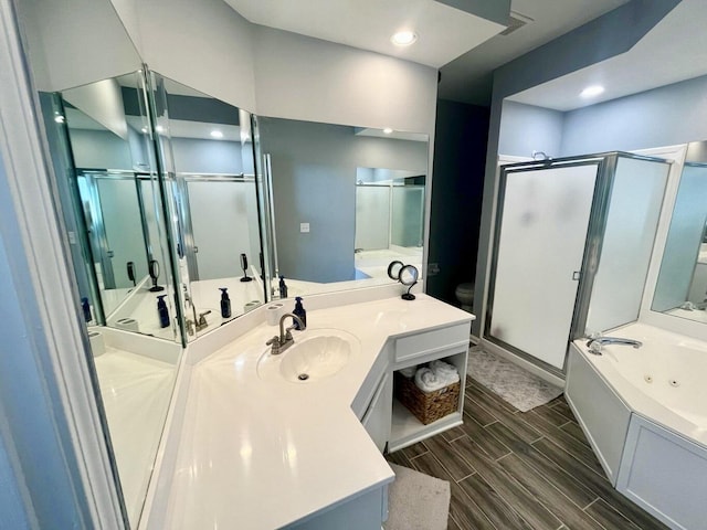 280 Woodland Dr Unit 2D, Branson, MO 65616 - bathroom featuring a shower stall, a tub with jets, vanity, wood finish floors, and recessed lighting