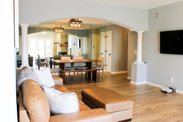 280 Woodland Dr Unit 2D, Branson, MO 65616 - living area with wood finished floors, baseboards, arched walkways, a fireplace, and decorative columns