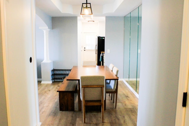 280 Woodland Dr Unit 2D, Branson, MO 65616 - dining space featuring a raised ceiling, light wood-style floors, ornate columns, and baseboards