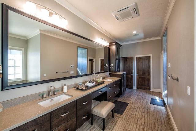 full bath with visible vents, wood finished floors, a sink, and ornamental molding