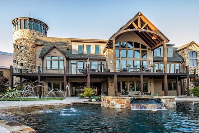 rear view of house featuring a pool with connected hot tub and a patio