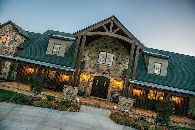 view of front of property featuring metal roof and stone siding