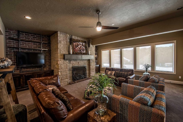 carpeted living room featuring a textured ceiling, a stone fireplace, a ceiling fan, and baseboards