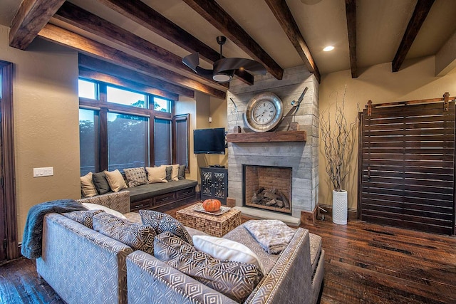 living room with a textured wall, a fireplace, beamed ceiling, and hardwood / wood-style flooring