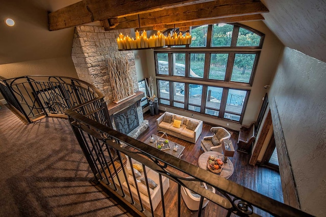 living area with vaulted ceiling with beams and a textured wall