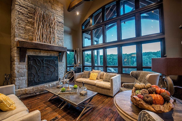 living room featuring hardwood / wood-style flooring, a fireplace, high vaulted ceiling, and beamed ceiling