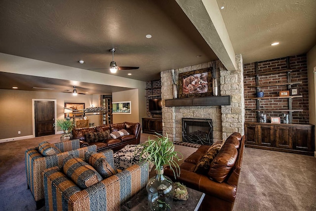 living room featuring a textured ceiling, carpet floors, a stone fireplace, and a ceiling fan