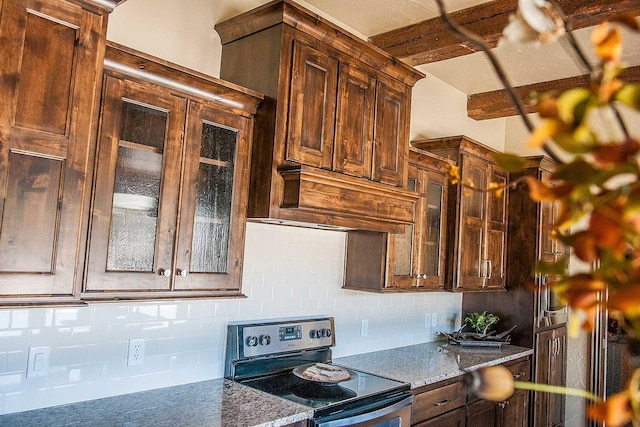 kitchen with glass insert cabinets, dark stone counters, stainless steel electric range oven, and backsplash