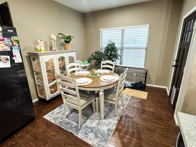 dining space with baseboards and wood finished floors