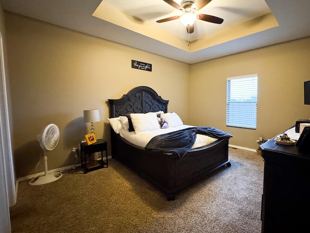 bedroom with ceiling fan, carpet, baseboards, and a raised ceiling