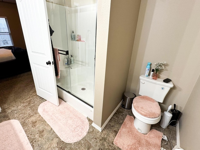 full bath with toilet, a stall shower, baseboards, and ensuite bathroom