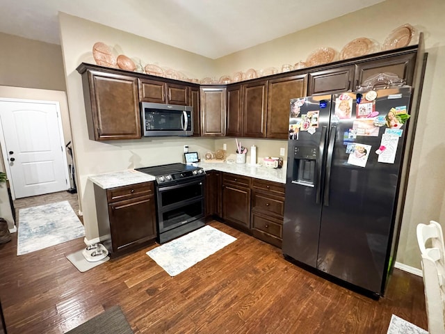 kitchen with dark wood-style floors, stainless steel appliances, light countertops, and dark brown cabinetry