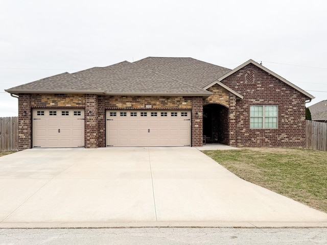 single story home featuring a garage, a shingled roof, fence, and brick siding