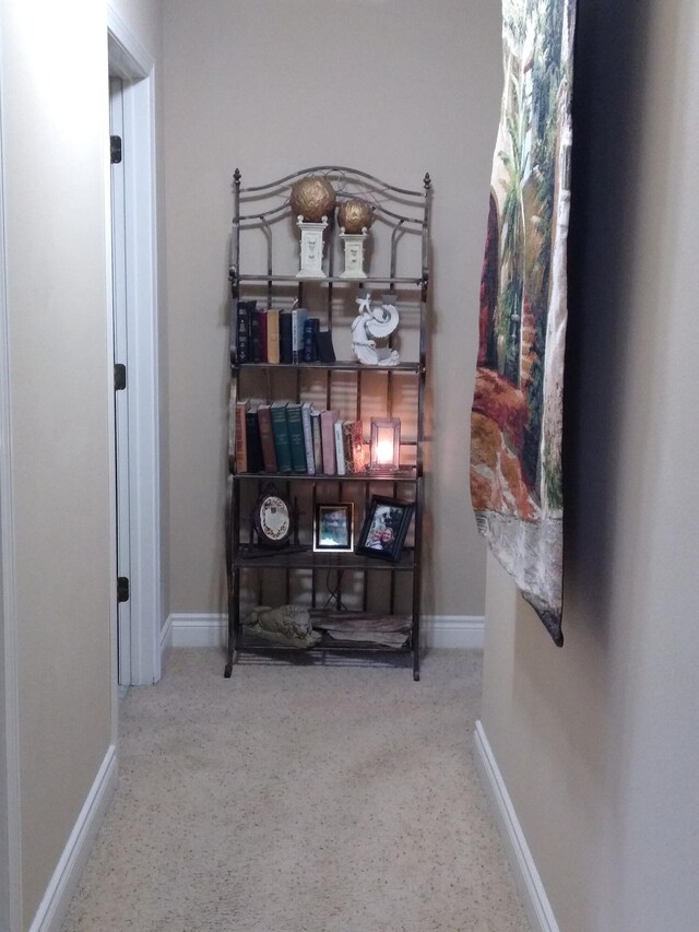 hall with baseboards and speckled floor