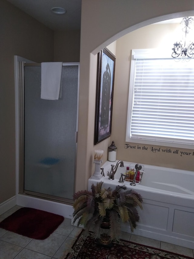 bathroom featuring a chandelier, a stall shower, a bath, and tile patterned floors