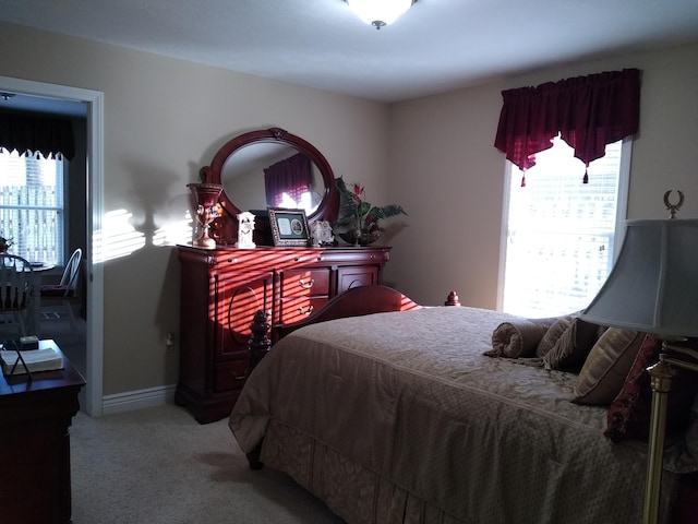 carpeted bedroom with multiple windows and baseboards