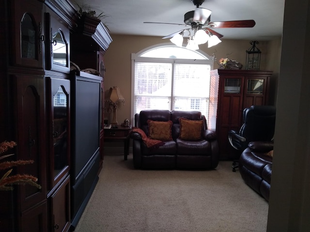 living area with a ceiling fan and light colored carpet
