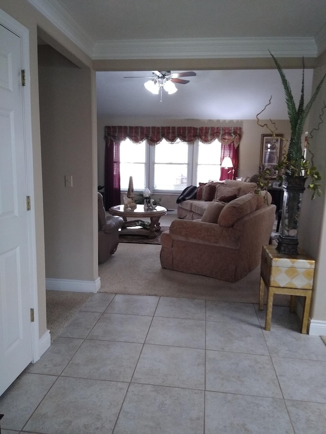 living room with light tile patterned floors, ceiling fan, ornamental molding, and baseboards