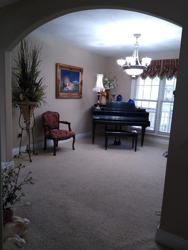 living area with a chandelier, carpet, arched walkways, and baseboards