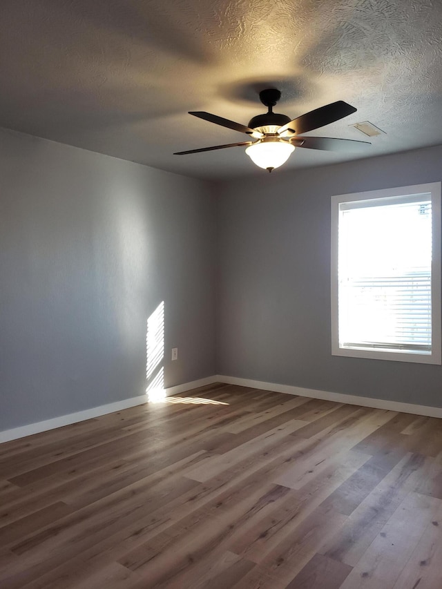 unfurnished room with visible vents, baseboards, and wood finished floors