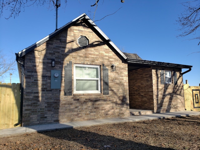 view of home's exterior with fence and brick siding