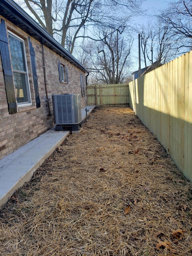 view of yard featuring a fenced backyard and central AC