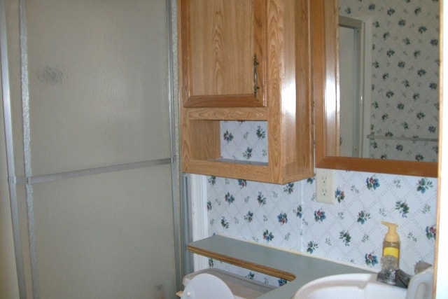 bathroom featuring toilet and wallpapered walls