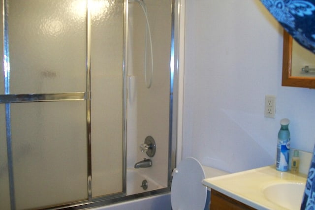 bathroom with toilet, bath / shower combo with glass door, and vanity