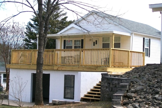 back of property with a shingled roof, stairs, and a porch