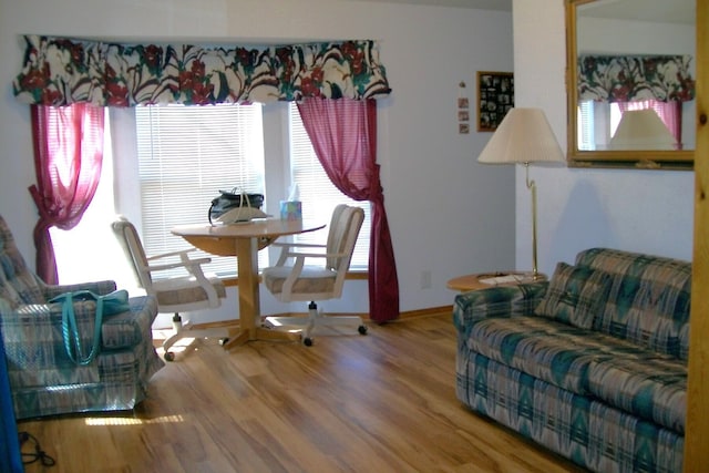 dining space with baseboards and wood finished floors