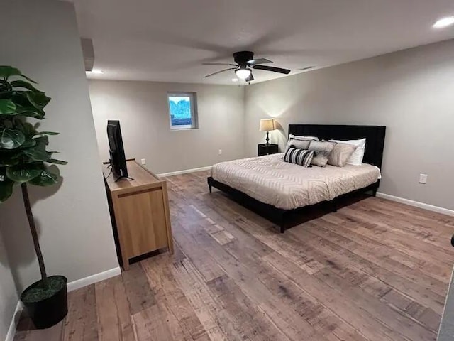 bedroom featuring light wood-style flooring, baseboards, and ceiling fan