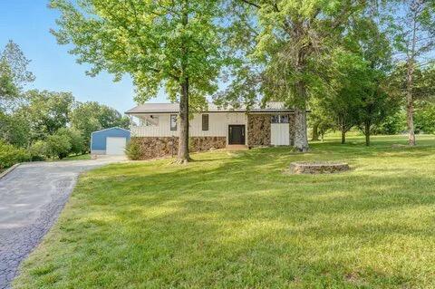 view of front of home featuring an outdoor structure, driveway, and a front lawn