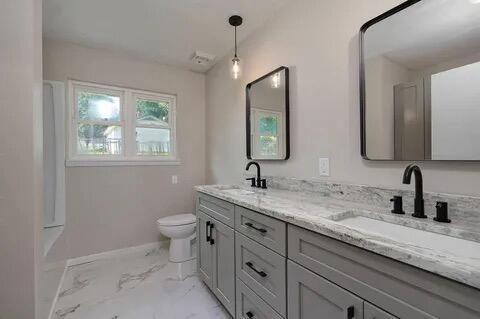 full bathroom featuring toilet, marble finish floor, double vanity, and a sink