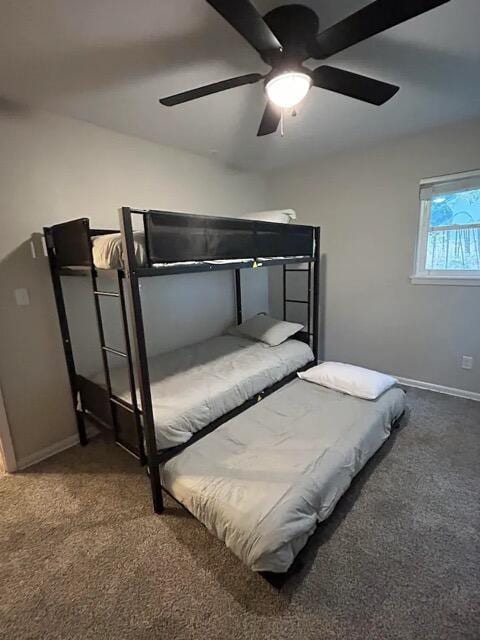 carpeted bedroom with ceiling fan and baseboards