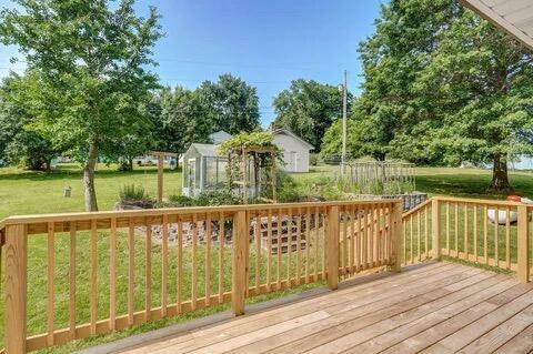 wooden deck featuring an outbuilding, an exterior structure, and a lawn