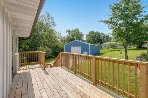 wooden deck with a yard and an outdoor structure