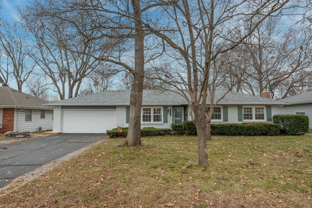 single story home with a garage, driveway, a front yard, and brick siding