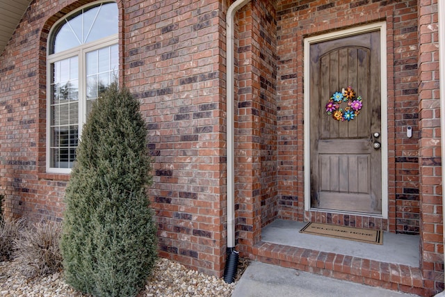 doorway to property featuring brick siding