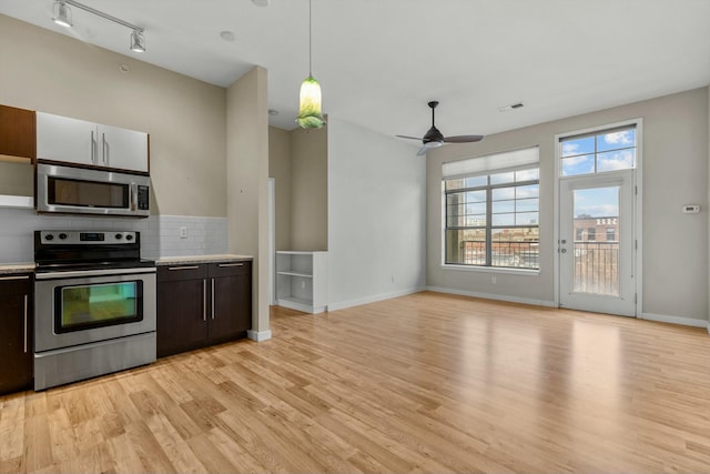 kitchen with stainless steel appliances, light wood-type flooring, light countertops, and visible vents