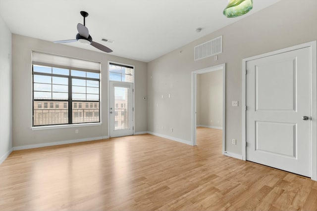 spare room with light wood finished floors, baseboards, visible vents, and ceiling fan