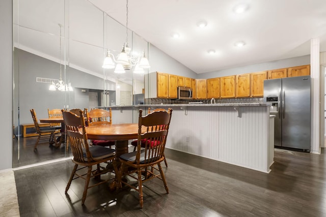 dining area with lofted ceiling, dark wood-style flooring, visible vents, and an inviting chandelier