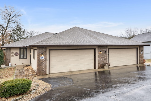 ranch-style home with a shingled roof, an attached garage, and brick siding